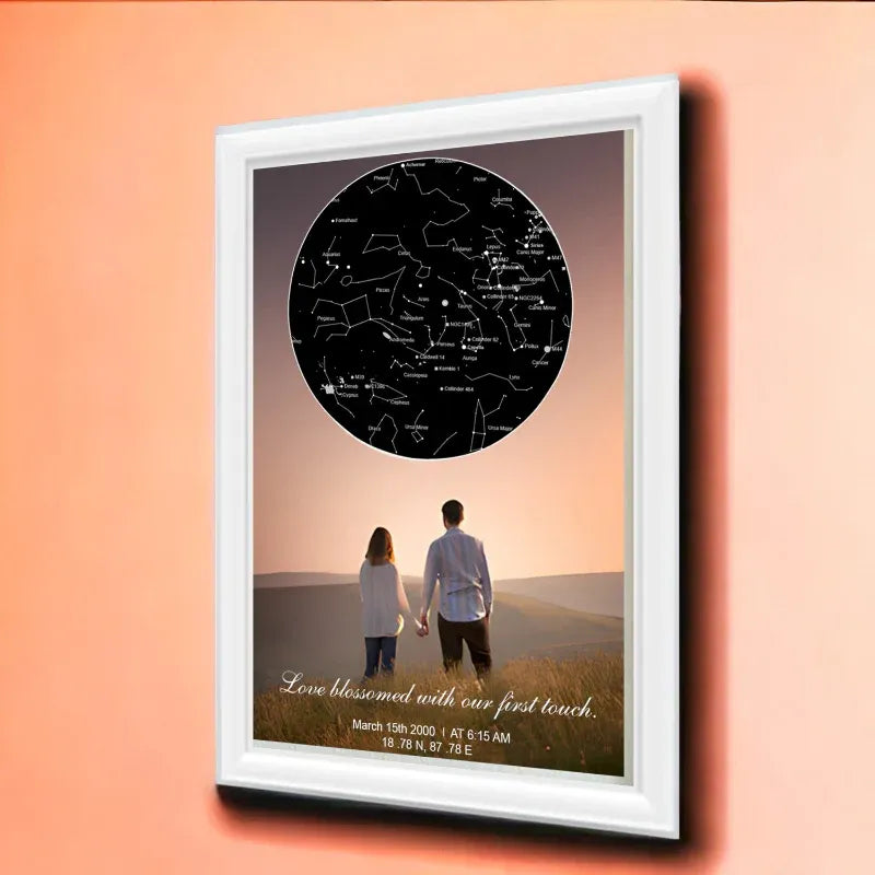 Framed artwork of a couple holding hands with a star map above them on a peach background