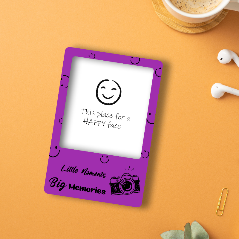 Purple digital frame with a smiley face design on an orange surface with a cup of coffee and earbuds.