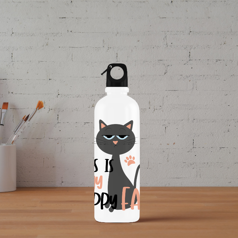 A white sipper water bottle with a black cat design and text 'It's ok to be happy' on a table with a brick wall background and some art supplies.