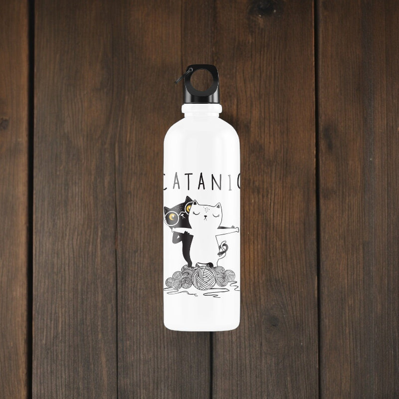 White water bottle with black cat illustration on a wooden surface