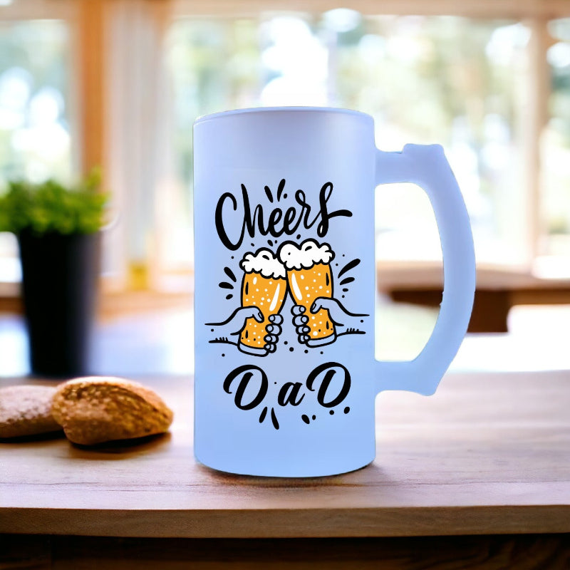 A blue beer mug with 'Cheers Dad' printed on it, placed on a wooden surface with a blurred background.