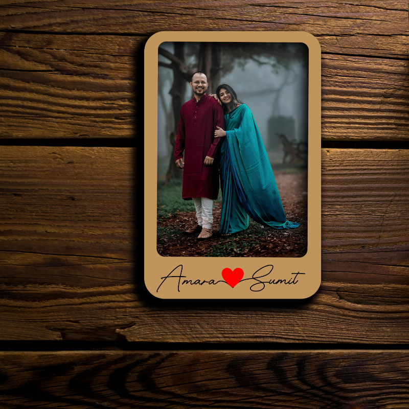 Wooden photo frame with a couple in traditional attire on a wooden background