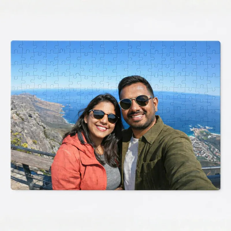 Jigsaw puzzle with a scenic background of a couple taking a selfie by the ocean.