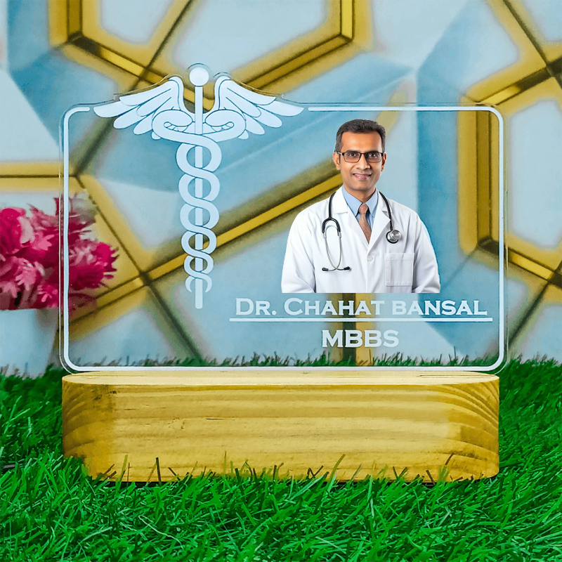 A personalized photo lamp with a picture of a doctor and the name 'Dr. Chahat Bansal MBBS' illuminated on a wooden base.