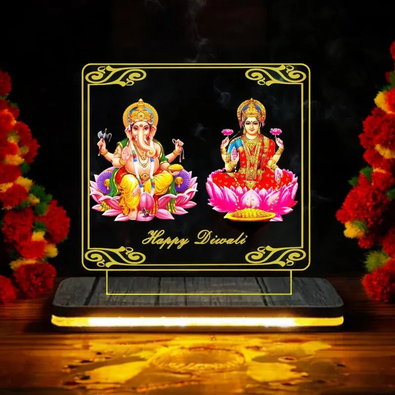 Decorative light box with Lord Ganesha and Goddess Lakshmi on a black background with flowers.