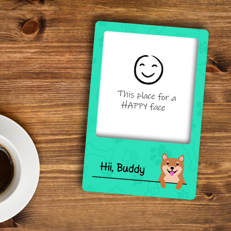 Teal card with a smiley face and text on a wooden surface with a cup of coffee.