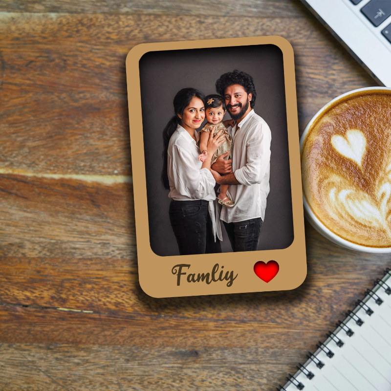 Wooden photo frame with a family portrait on a wooden surface with a cup of coffee.