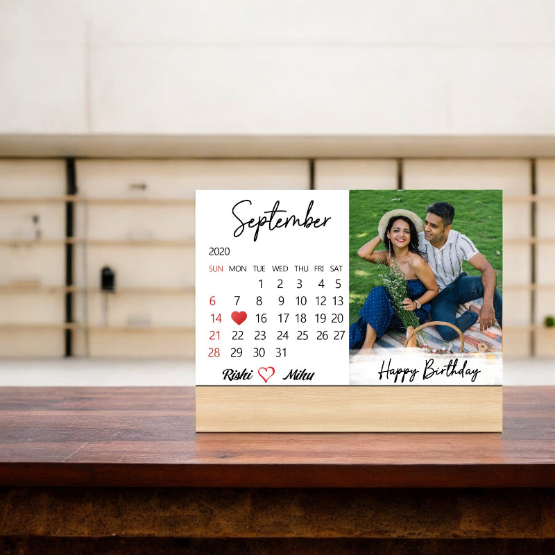Calendar with a photo of a couple and personalized text on a wooden surface
