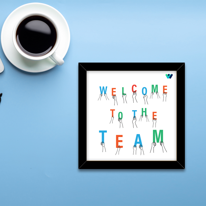 Framed artwork with 'Welcome to the Team' text on a blue background with a cup of coffee.