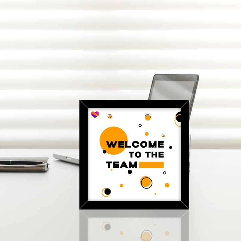 Decorative sign with 'Welcome to the Team' text on a white surface with a blurred background