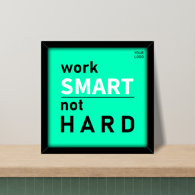 A framed inspirational office decor sign with the text 'work SMART not HARD' on a turquoise background, with a placeholder for a logo, displayed on a wooden surface.