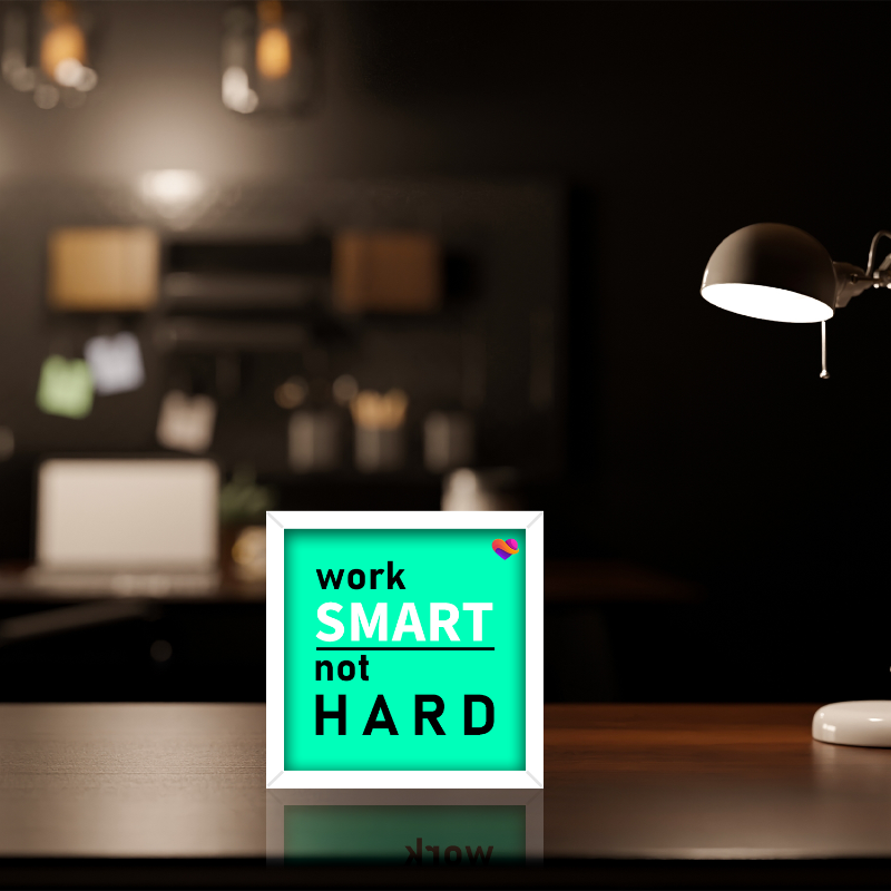 Desk setup with a motivational sign reading 'work SMART not HARD' in a home office setting.