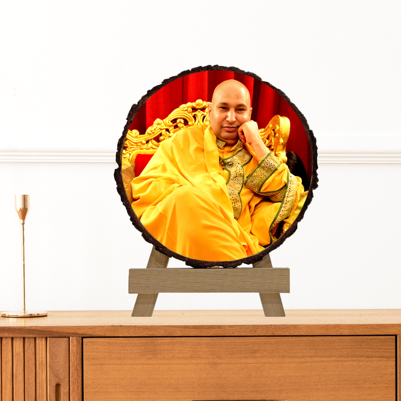 A circular photo frame featuring a portrait of a man in a yellow robe seated on a throne, set on a natural wood stand.