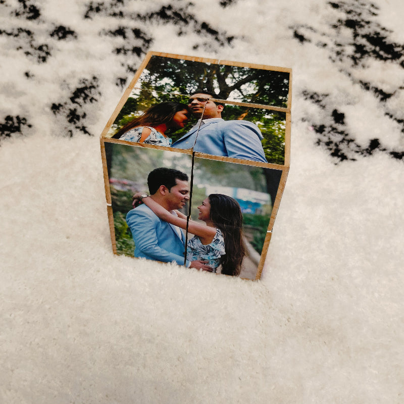 Wooden cube with photos of a couple on a textured surface