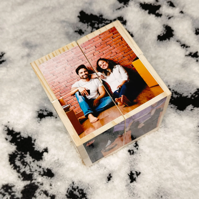 Wooden photo puzzle with a couple on a brick wall background, placed on snow.