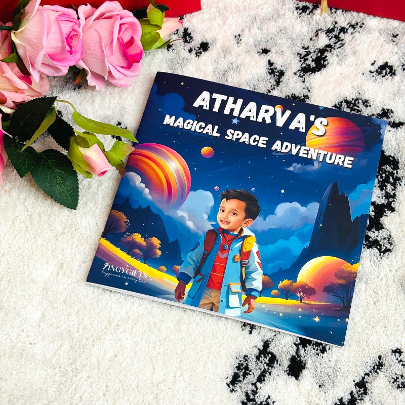 Children's book titled 'Atharva's Magical Space Adventure' with a space-themed cover featuring a child and planets, surrounded by pink roses on a textured white surface.