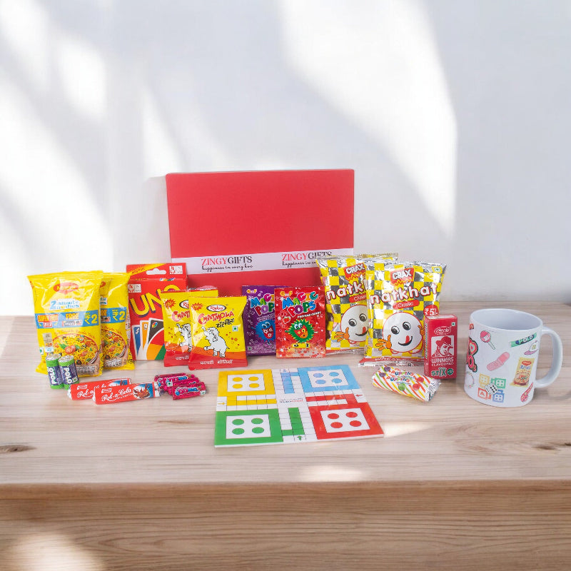 Collection of colorful snacks, toys, and a mug on a wooden surface with a white background