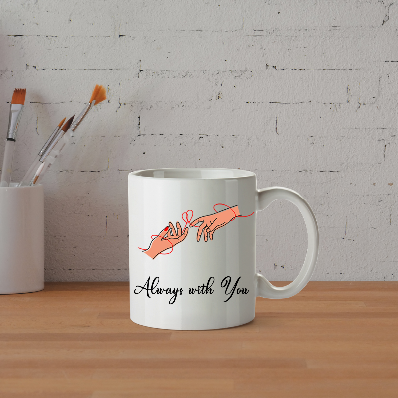 White mug with 'Always with You' design on a wooden surface with a white brick wall background.