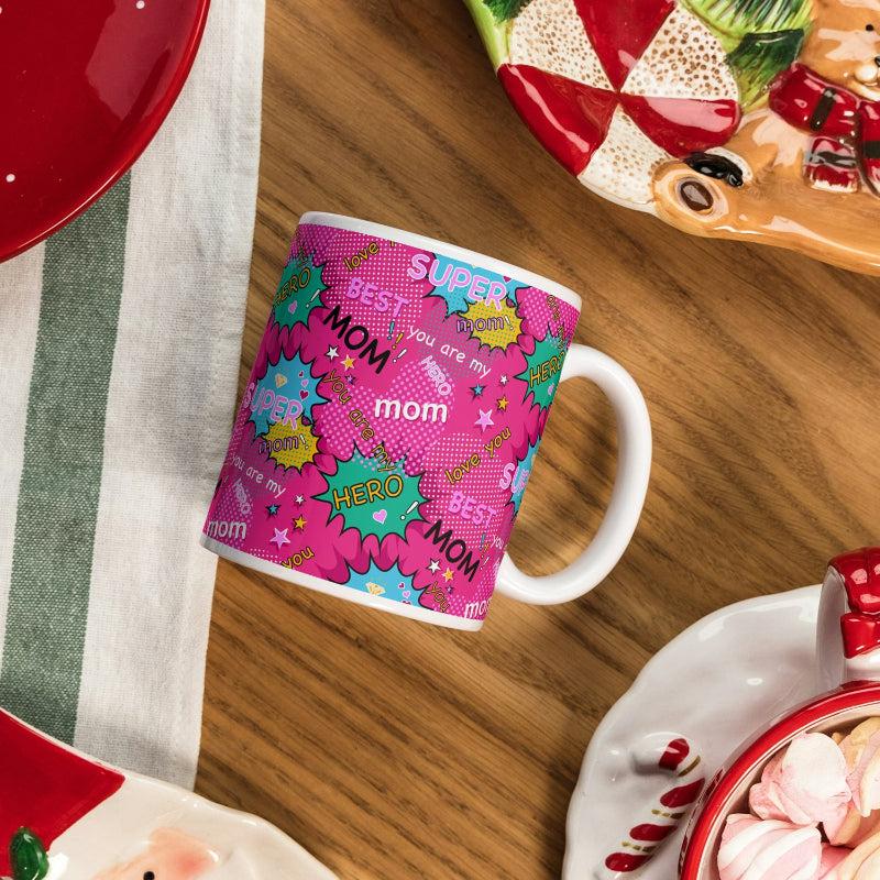 A colorful ceramic mug with text and graphics expressing love and admiration for a mother, placed on a kitchen counter.