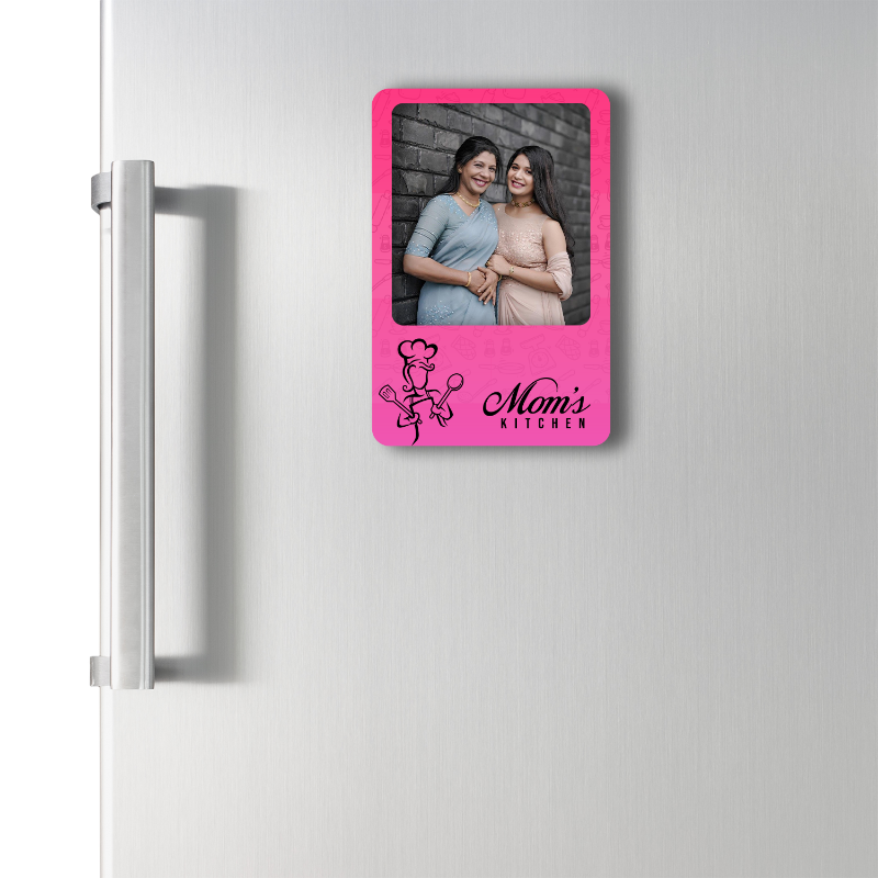 Pink photo frame with 'Mom's Kitchen' text attached to a refrigerator.
