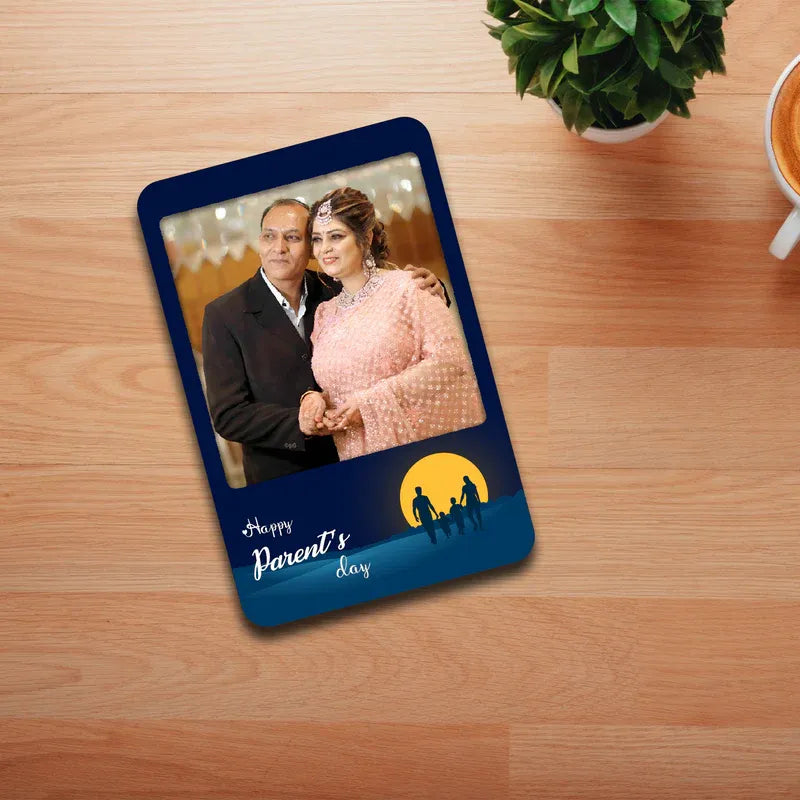 Photo Magnet with a photo of a couple on a wooden surface with a plant and cup.
