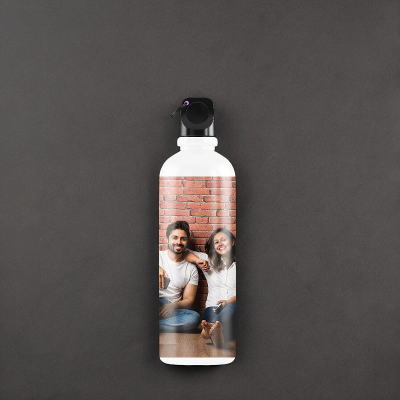 Personalized water bottle with a photo of two people on a brick wall background