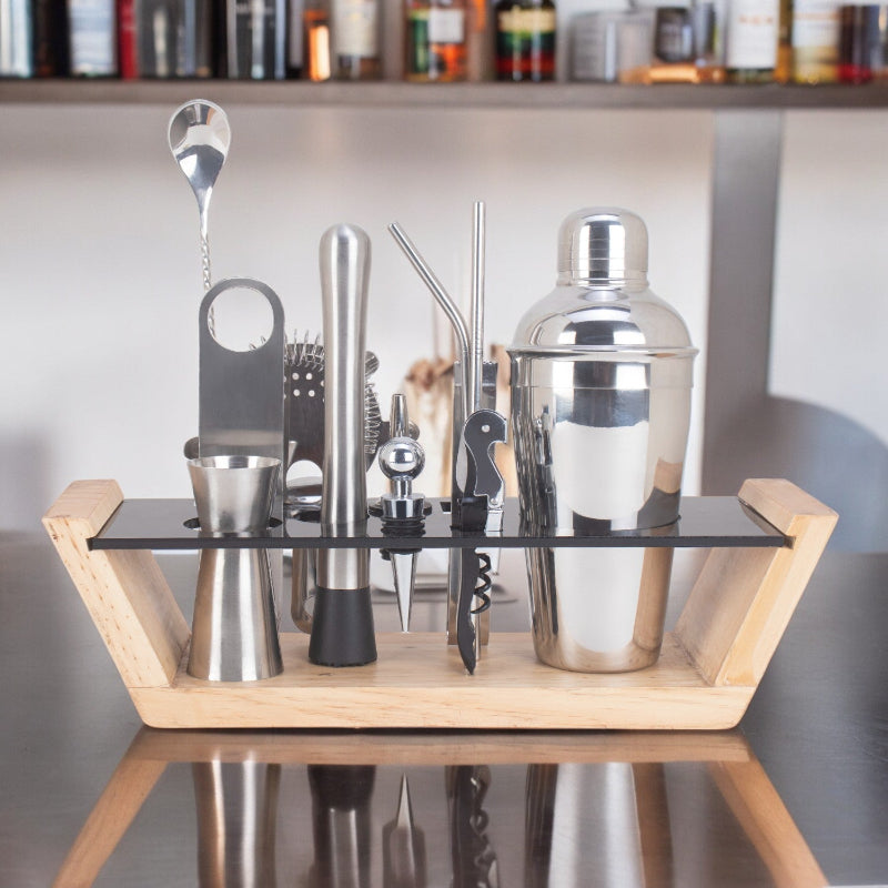 Set of cocktail-making tools on a wooden stand with a blurred background