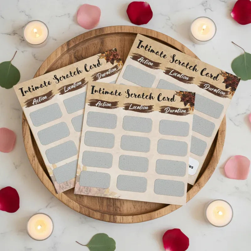 Intimate Scratch Card packaging on a wooden plate with candles and rose petals in the background