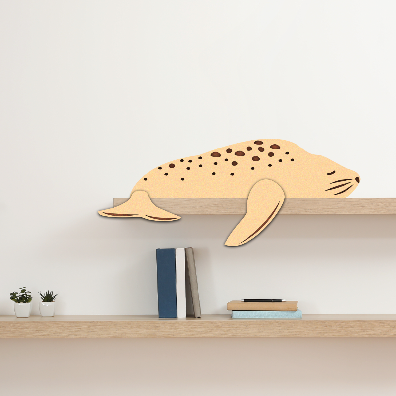 Wooden seal-shaped shelf on a white wall with books and plants below.
