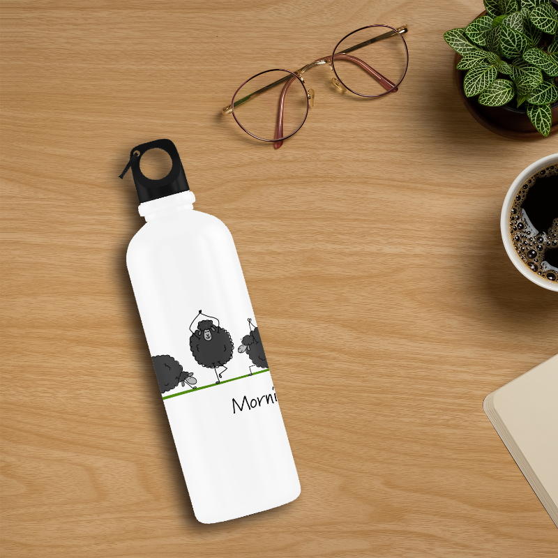 White water bottle with black sheep design on a wooden surface with glasses and coffee.