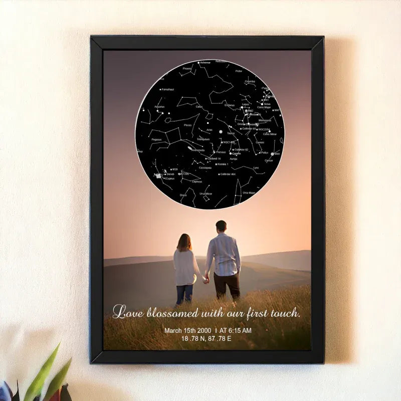 Framed artwork of a couple holding hands with a star map above them on a wall.