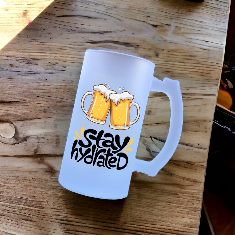 Frosted mug with beer mugs and 'Stay Hydrated' text on a wooden surface