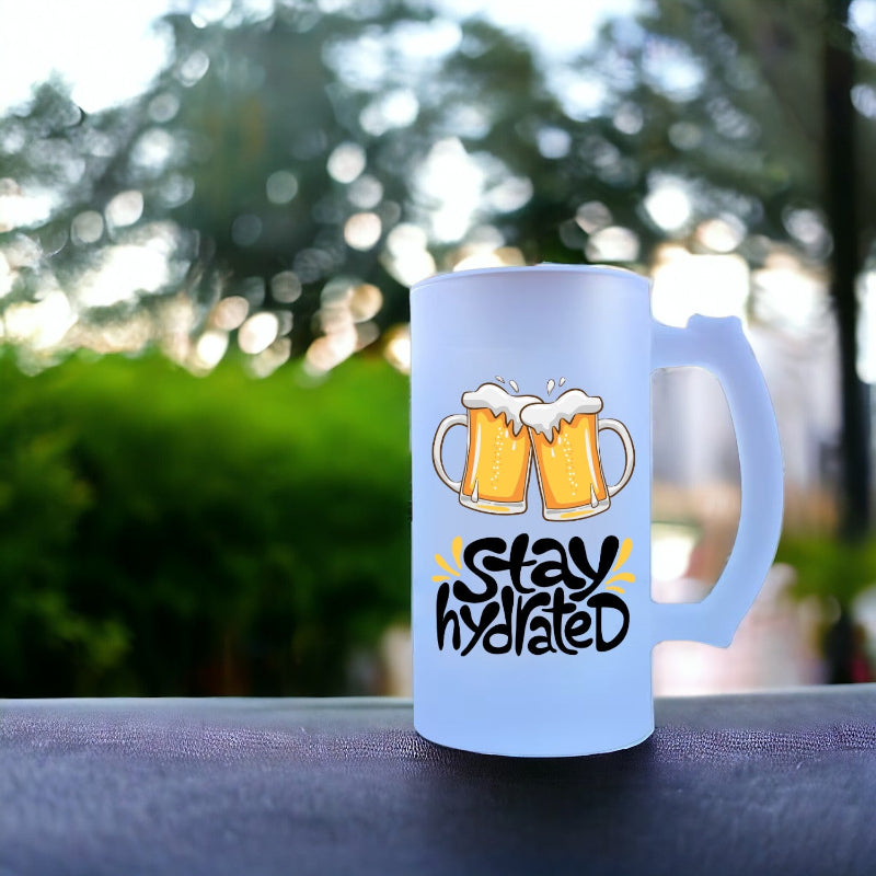 Frosted mug with beer mugs and 'Stay hydrated' text on a blurred outdoor background