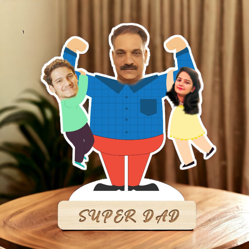Decorative stand with cut-out figures of a man, a boy, and a girl, labeled 'Super Dad', on a wooden surface.