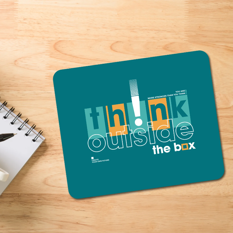 Teal mouse pad with 'Think outside the box' text on a wooden surface