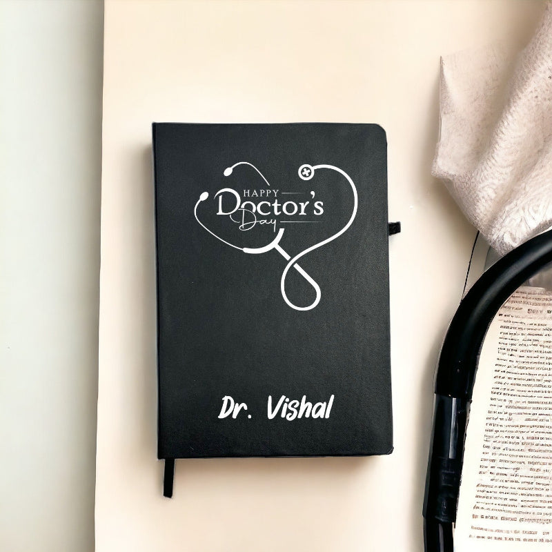 Black notebook with 'Happy Doctor's Day' and a stethoscope design, personalized with 'Dr. Vishal', on a light background.