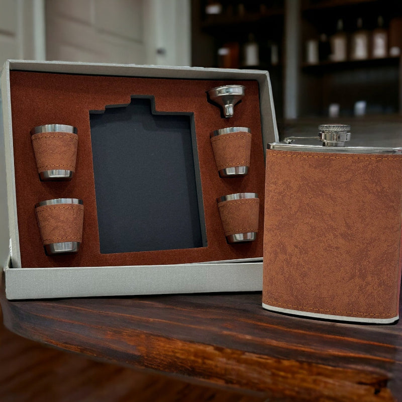 Brown leather flask set with four cups on a wooden surface