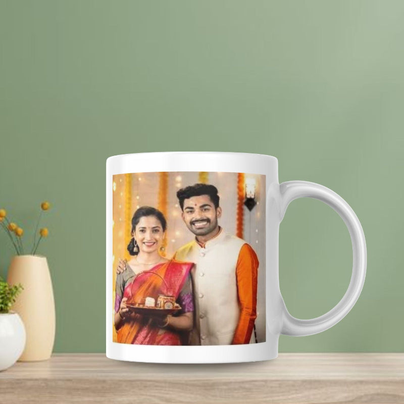 White mug with a printed design of a couple on a wooden table against a green wall.