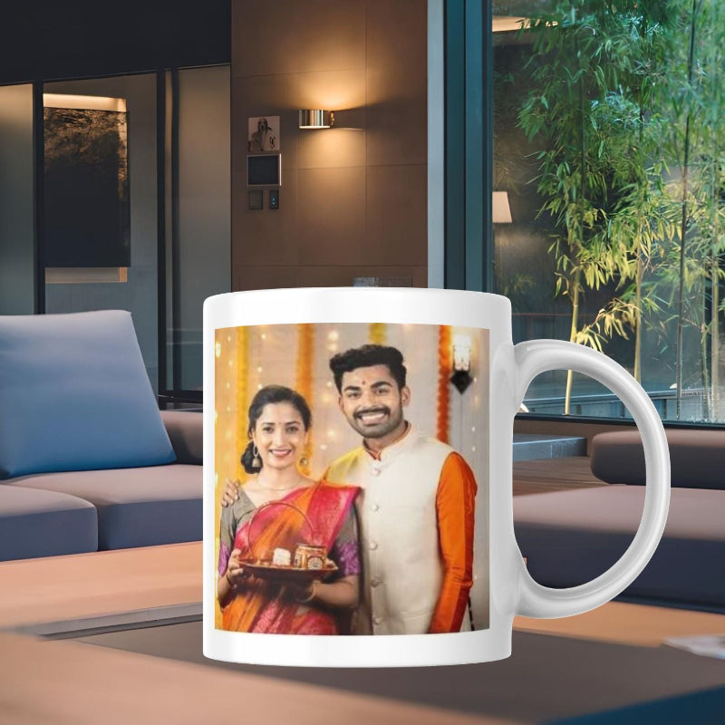 White mug with a printed design of a couple in traditional attire on a table in a modern living room.