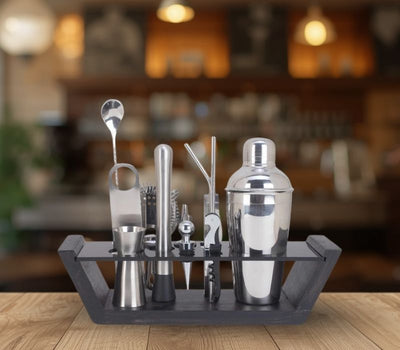 Set of bar cocktail-making tools on a tray with a blurred bar background
