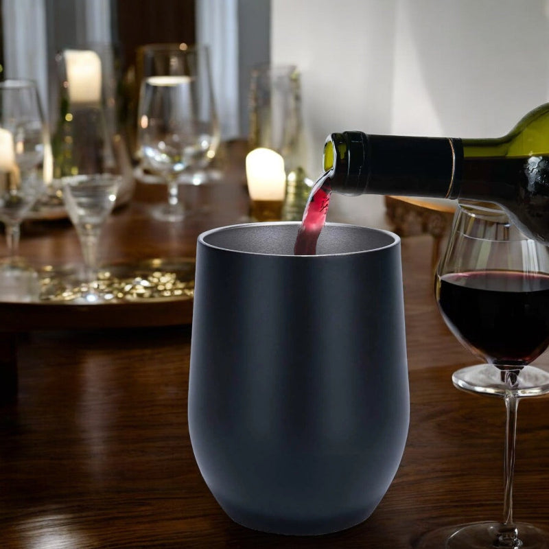 Blue wine glass being filled with red wine on a candlelit table.