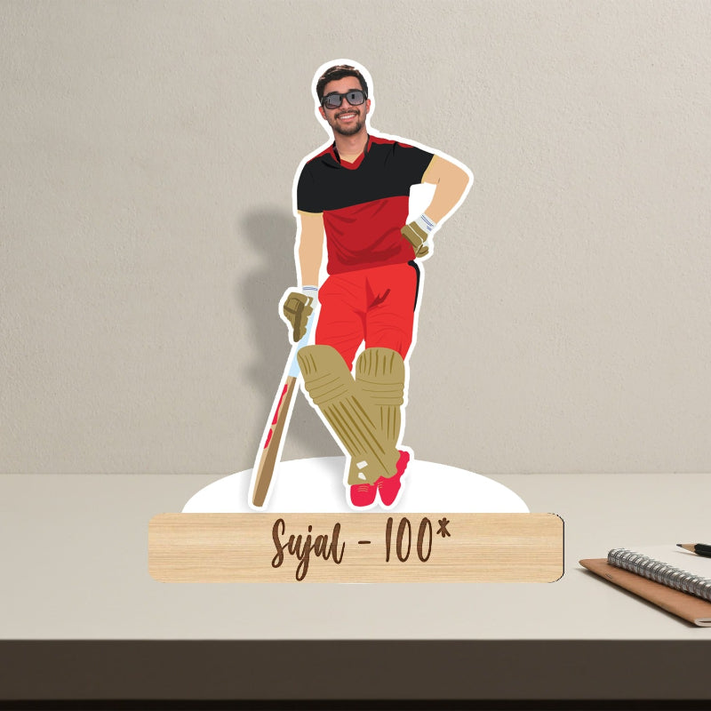 Cocktail stirrer with a cricket player design and 'Sujal - 100*' text on a beige background
