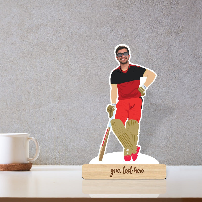 A 3D caricature of a cricketer in red and black standing on a wooden stand with the text 'You Lifted Here'.