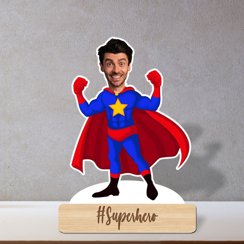 Superhero caricature with a person inside, standing on a gray background with '#Superhero' sign below.