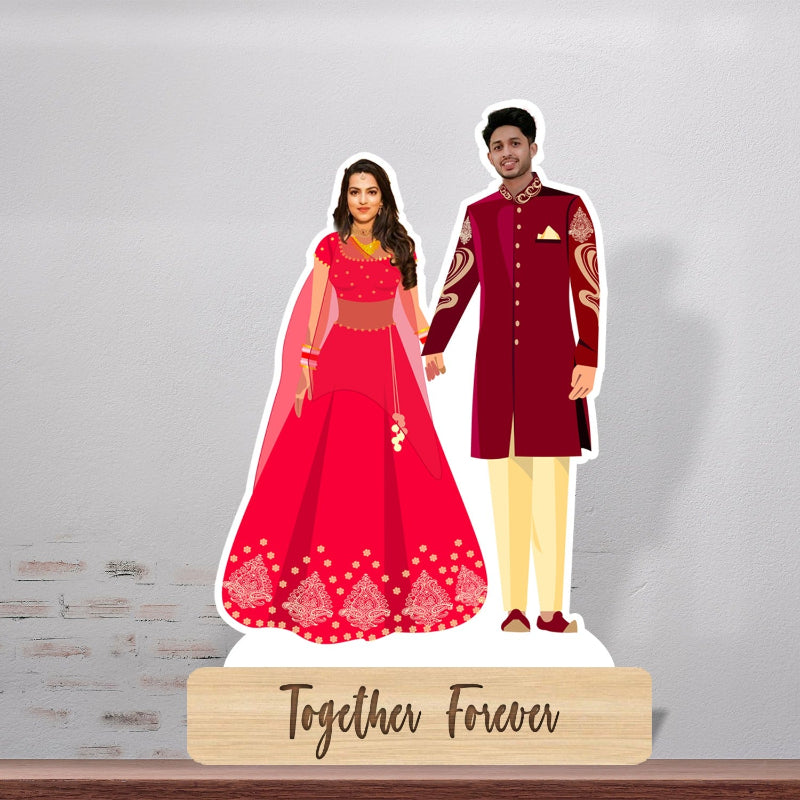 A personalized couple caricature standing on a wooden stand, with the woman in a red dress and the man in a suit, surrounded by a 3D effect.