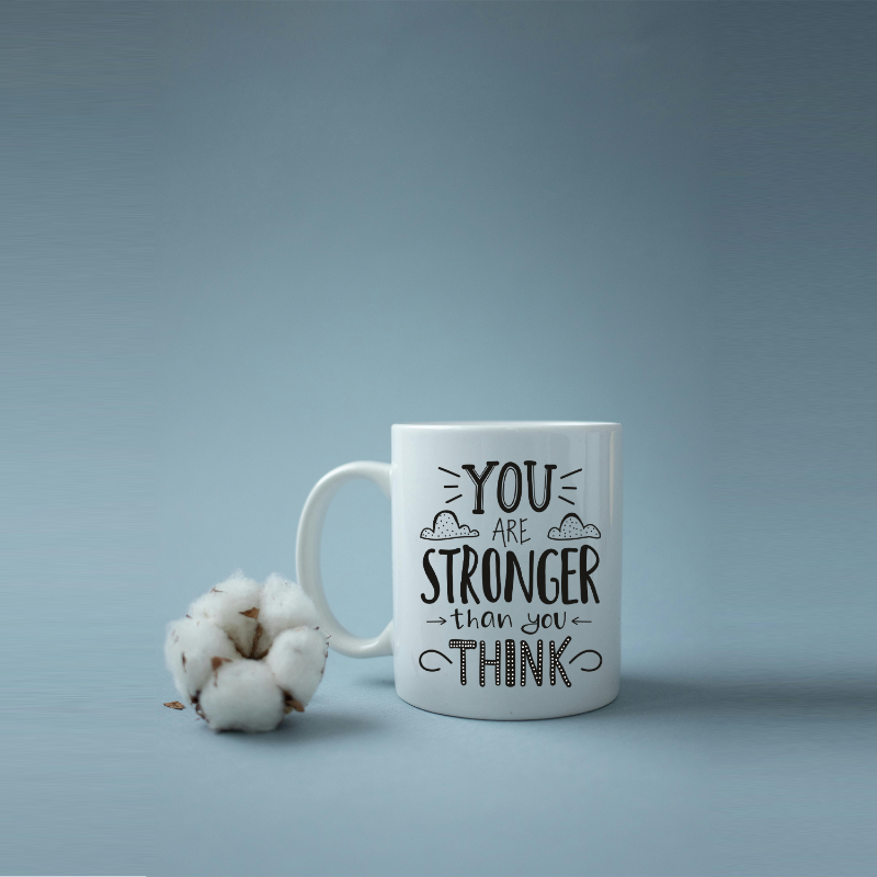 White mug with motivational quote on a light blue background