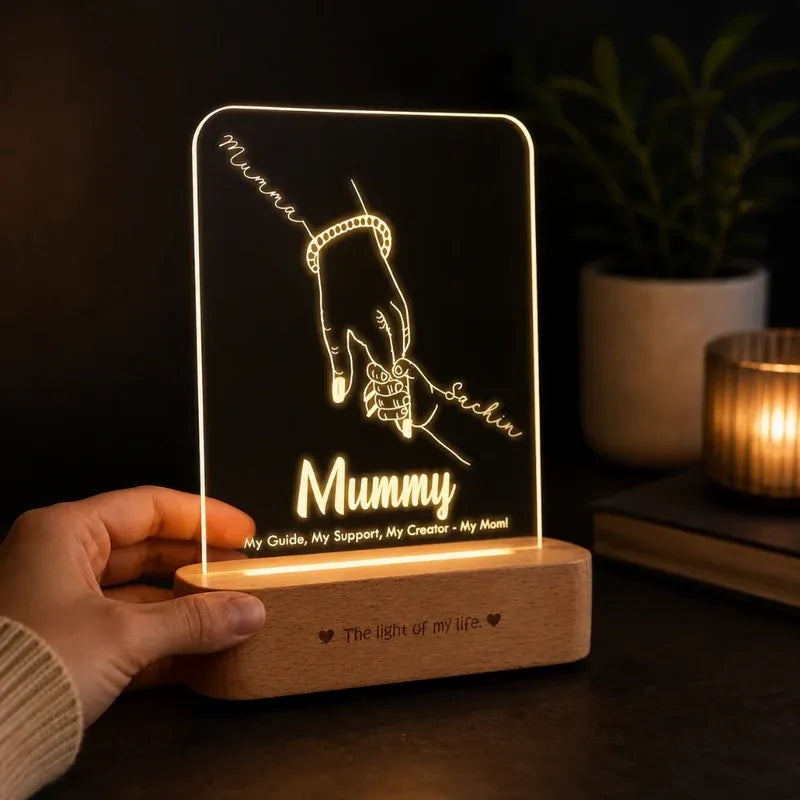 LED night light with engraved design and text, held by a hand.