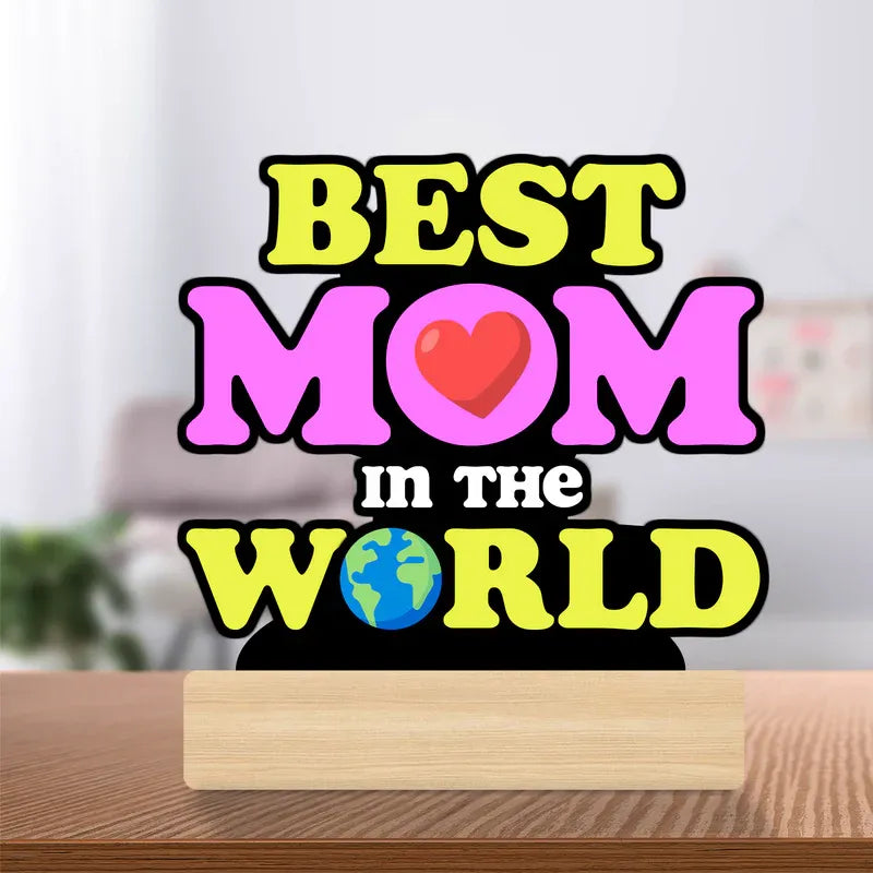 Decorative sign with 'Best Mom in the World' text on a wooden surface.