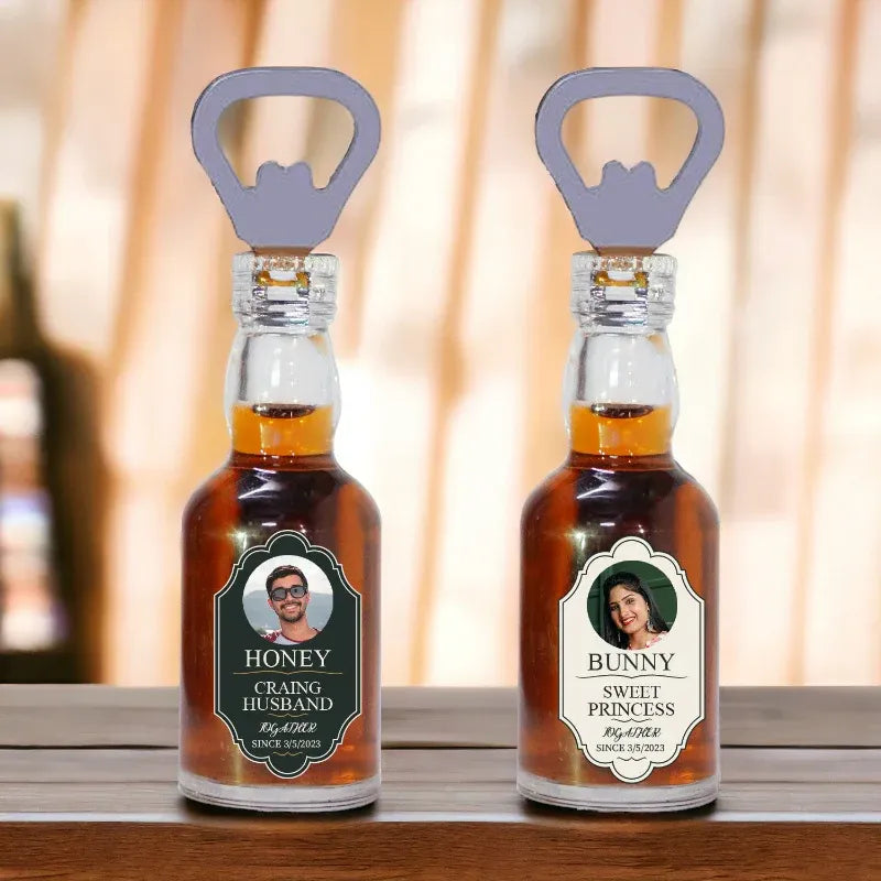 Two bottles with personalized labels and bottle openers on a wooden surface.