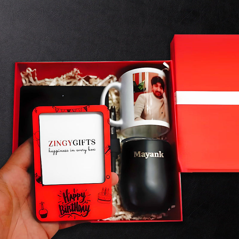 A birthday gift hamper by Zingy Gifts, containing a coffee mug with a photo, a birthday card, and a small gift, all presented in a red gift box with 'Happy Birthday' text.